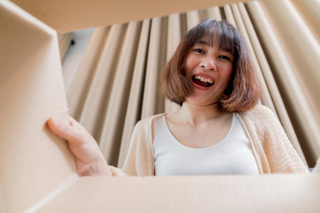 A cute smiling woman opened the box and looked inside. move and unpack conceptの写真素材