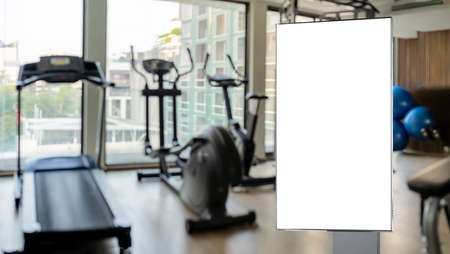 Blank billboard or poster located in gym. interior of modern fitness center gym with equipmentの写真素材