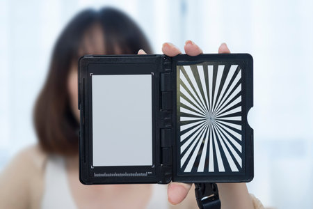 Custom white balance in the hands of a girl. The model holds a custom white balance in its hands for white balance transfer during further.の写真素材