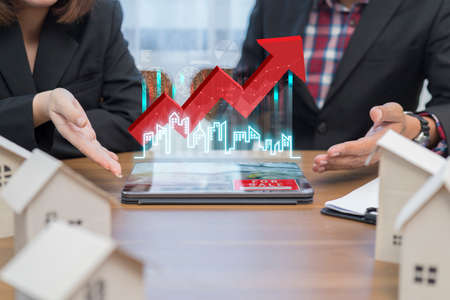 Concept of Property investment and house mortgage financial. A business man, agent calculating income, sales or house. Real-estate agent showing house plans on electronic tablet.の写真素材