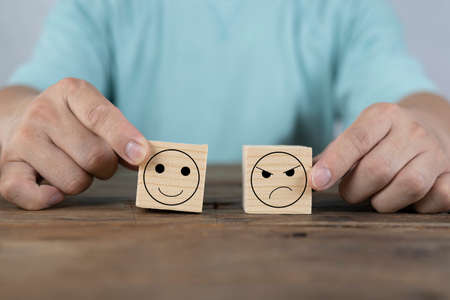 Customer service evaluation and satisfaction survey concept. Hand picked the happy face emoticon on wooden blocks. Copy spaceの写真素材