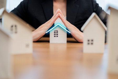 Female businesswoman hands protecting house. Home protecting concept for insurance or securityの写真素材