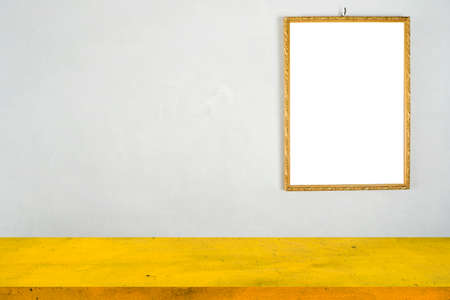 A yellow iron table in front of a cement wall with a golden frame. White label floor for text, images, advertising media.の写真素材