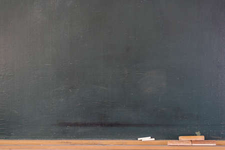 Blank blackboard with colored chalks and eraser and light effect. Horizontal composition.の写真素材