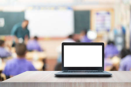 Computer laptop on the table, blur image of the children classroom as background.の写真素材