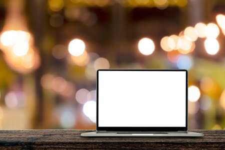 Desk Laptop with blank screen on table blur background with bokeh background that is used for editing.の写真素材