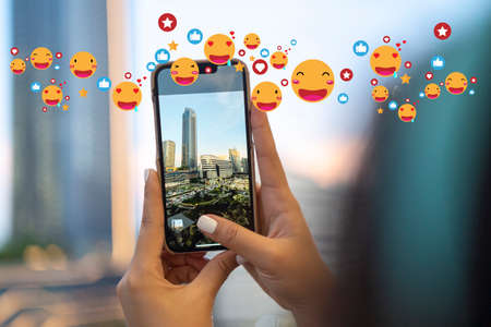 Girl vlogger using a smartphone to take photos and post on social media gets tons of likes from the...