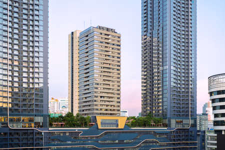 Skyscrapers with glass facade. Modern buildings in business. Evening dynamic traffic on a street. Business, economy and finances concept. Copy space for text. Tonedの写真素材