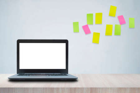 Resolutions, notes, goals, post, memo or action plan concept. Sticky notes on loft wall in workplace office with laptop on wooden desk.の写真素材