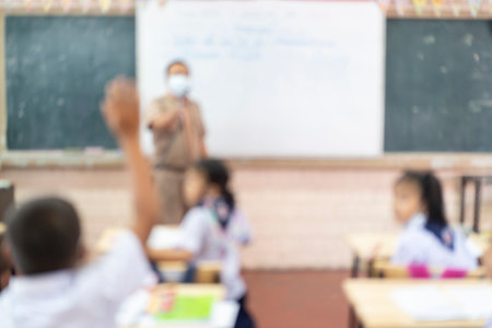 Kids with Teacher in the classroom, Blur Image For background. The teacher is asking questions to the students.の写真素材