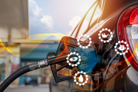 Oil refinery overlays and traffic lighting.Symbolic icons related to fuel energy.Refuel the car at the gas station at the gas station.The man refueled and refueled his car with gas at a gas station.の写真素材