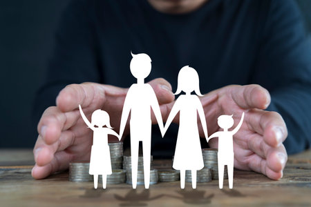 Businessman take a position to protect on paper family in hand, donation, saving, charity, family finance plan concept, fundraising, superannuation, financial crisis concepの写真素材