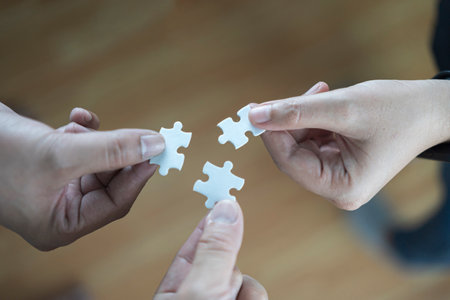 Hand holding jigsaw puzzles, Business partnership concept. Group of business people assembling jigsaw puzzle and represent team supportの写真素材