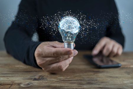 Light bulb with brain inside the hands of the businessman. The concept of the business idea with Brain inside and Low poly wireframe outside. Creative and innovation inspirationの写真素材