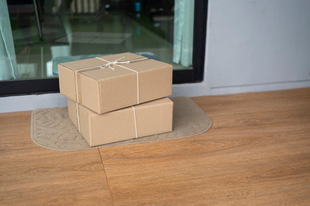 Carton box on the floor of entry of the house. Delivered parcels on door mat near entrance.の写真素材
