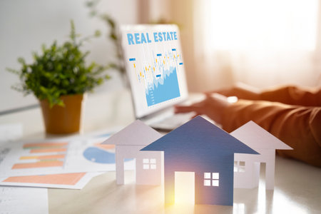 Business women are using their laptops for work and thinking about real estate investment concept. House model, investment graph. Businessman in real estatesの写真素材