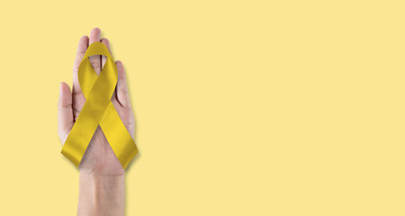 Childhood cancer awareness with gold ribbon isolated on white background  . Golden bow color for Embryonal Rhabdomyosarcoma, Neuroblastoma and Osteosarcoma awarenessの写真素材