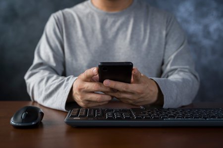 Cropped shot man holding and using mockup mobile phone in office. man use smartphone.の写真素材