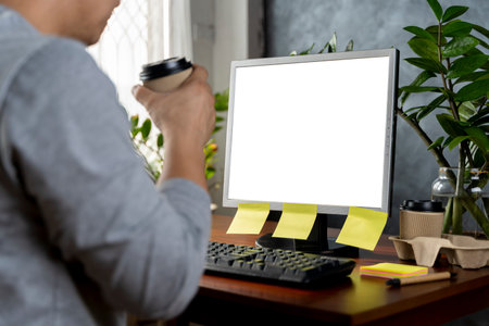 Concentrated businessman using computer watching online content at home. Blank white screen to insert advertising material.の写真素材