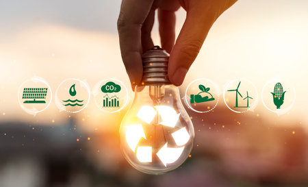 Hand holding light bulb with recycle symbol inside against with icons energy sources for renewable,...