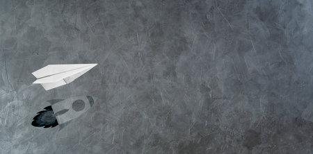 Start-up Company and Motivation in Business Concept. Paper Planes Flying with Shadow of Rocket over the Wallの写真素材
