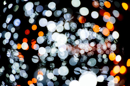 Blurred background. Christmas background with lights. Holiday light bulbs. Cosmic background. red, gold and black glitter lights. defocusedの写真素材