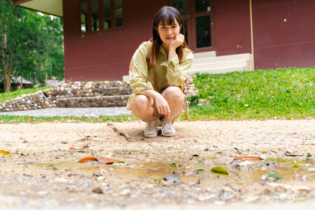 Female hiker with backpack looking sad Sit and look at the small pond with a calm mind.の写真素材