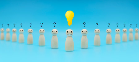Leader with idea and innovation and creativity concept. Creative process concept and problem solution. happy face wooden human and glowing light bulb. Standing out from the crowd.の写真素材