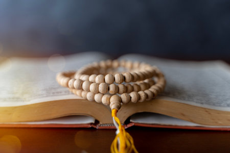 Quran with written arabic calligraphy meaning of Al Quran. Ramadan Mubarak. Ramadan kareem. Holy Islamic Book Koran with rosary beads on wooden background.の写真素材