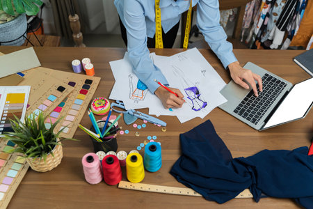 Designer concept.The dressmaker is designing an evening dress in the room.The tailor is working at...