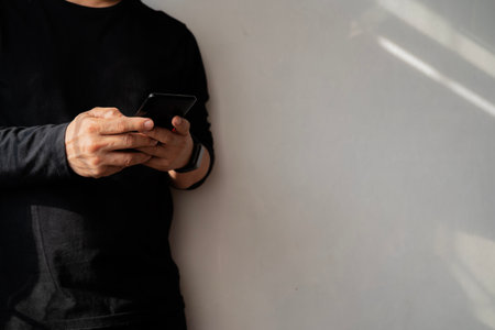 Businessman holding smartphone and pointing with one finger on important message, in casual clothes...