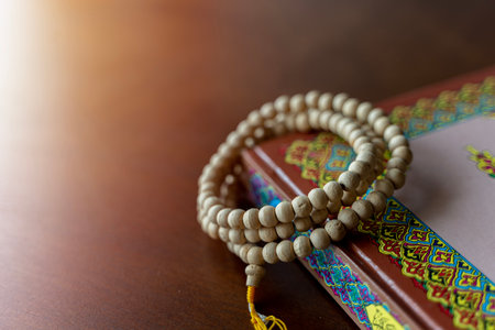 Holy Islamic Book Koran with rosary beads on wooden background. Quran with written Arabic calligraphy meaning of Al Quran. Ramadan Mubarak. Ramadan kareem.の写真素材