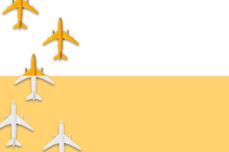 Flat lay design of travel in summer concept. Top view of an airplane on blank white and yellow pastel color screen with copy space. travel on summer trip on pastel color background concept.の写真素材