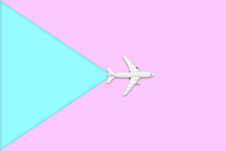 Flat lay design of travel in summer concept - Top view of an airplane on blank pink and blue pastel...
