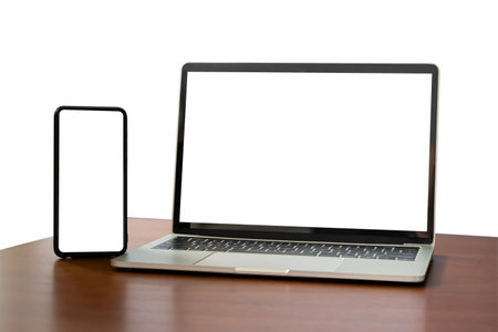 Blank screen notebook, laptop and mobile phone on isolated wooden table background with clipping path. Front view. Full screen smartphone and laptop mockup design. Digital device set.の写真素材