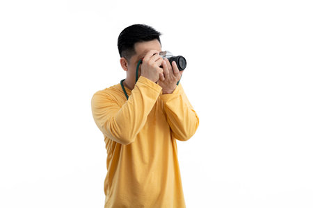 Successful professional photographer use DSLR digital camera iso. Professional male photographer with digital camera shooting in white isolated photo studio.の写真素材
