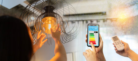 Woman change a new electric bulb, open air conditioning 26 degrees make a home more energy efficient. Home appliance energy efficient. Household equipment and energy class chart. Power saving concept.の写真素材