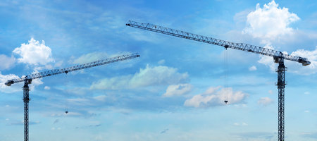 Construction crane working on building site against blue background bottom view of industrial crane Apartment building construction concept and residential renovation. Copy panoramic areaの写真素材