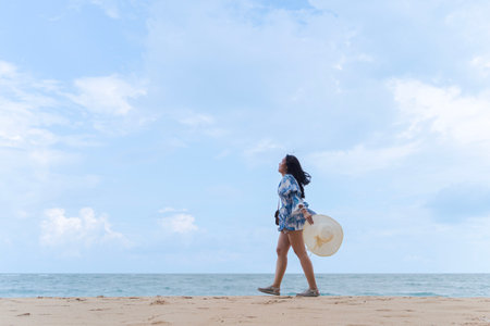 Kata beach Phuket Thailand on a sunny day with a blue sky, Asian women walks on the beach women of Ko Kham Island, south of Thailand. Good seascape of blue sea blue sky.の写真素材