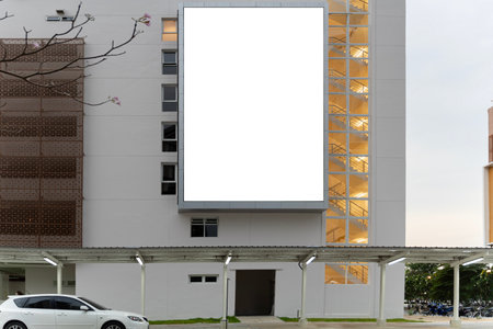 Empty white billboard on building. Modern ad and commercial concept. Mock up. A large blank billboard on a street wall signboard with room to add your own message.の写真素材
