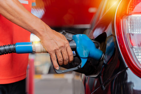 Refueling the car at a gas station fuel pump. Man driver hand refilling and pumping gasoline oil the car with fuel at he refuel station. Car refueling on petrol station. Fuel pump at stationの写真素材