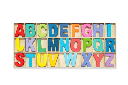 Colorful alphabet, wooden uppercase letters placed in a box, white isolated background.の写真素材