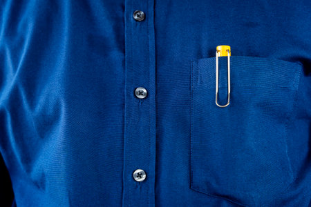 Close up pocket with yellow and silver pens and buttons on a blue striped shirt for men. Pen In Shirt Pocketの写真素材