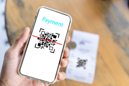 Male hand holding a smartphone with qr code on the screen. scanning the qr code. Barcode reader. Cashless technology, Digital money concept.の写真素材