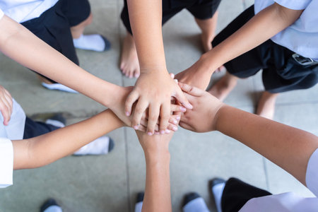School children use hand-to-hand coordination to combine power in activities. Friends putting their hands together. Close upの写真素材