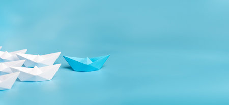 Leadership concept using blue paper ship among white. Origami Paper Boat, Ship, Teamwork and Leadership, Business Concept,の写真素材