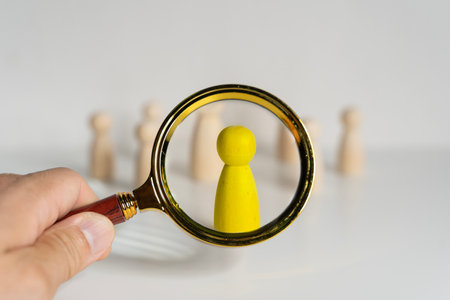 Wooden doll stand group with magnifying glass find search for teamwork business planning of relationship or HR human resources officer or business team and personnel management job performance.の写真素材