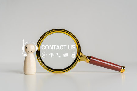 Phone and e-mail icons on Magnifying glass with contact us text on white background. Web page contact us or e-mail marketing concept.の写真素材