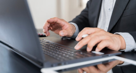 Businessmen having working on laptop computer, using digital tablet and mobile phone during meeting...