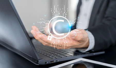 Copyright or patent. Businessman with copyright technology symbol on virtual screen for author rights and patent intellectual property. Ethical corporate culture concept and copyright law complianceの写真素材